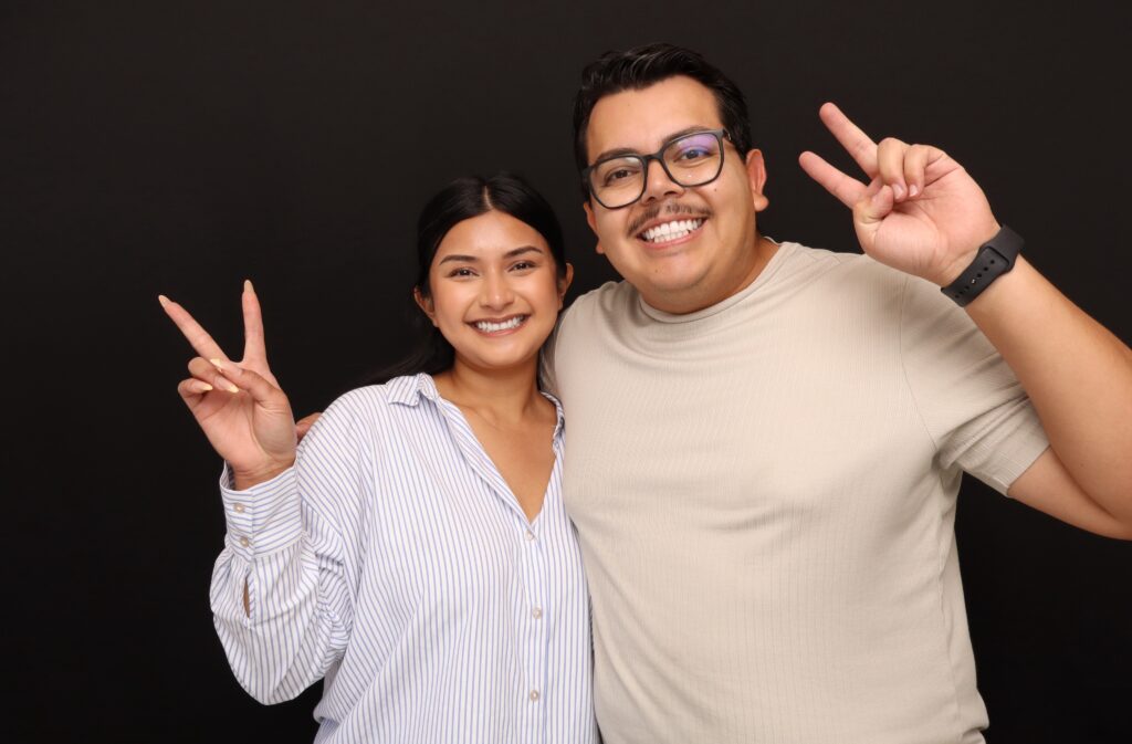 Two guests posing in a 29PM photo booth with a black backdrop
