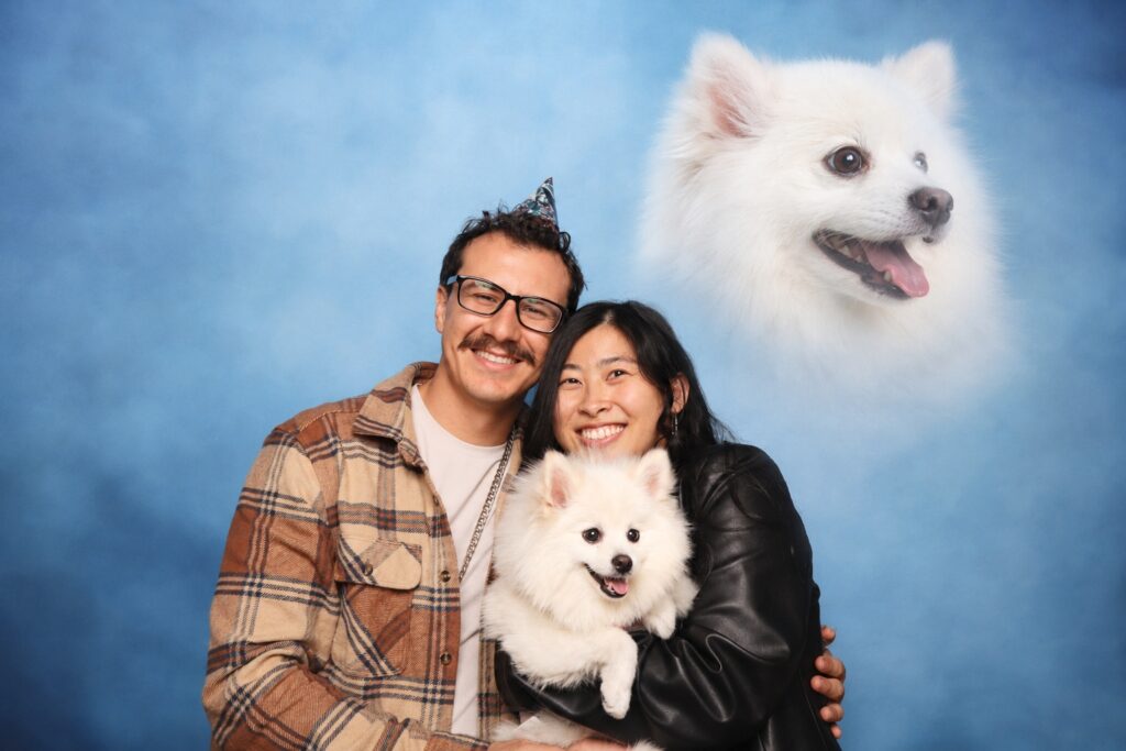 Couple posing with their dog in a 29PM AI photo booth portrait
