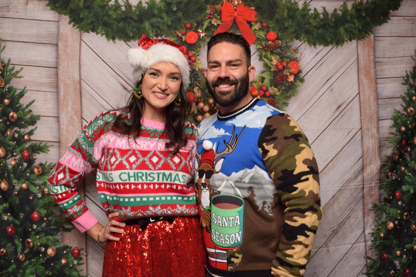 Couple in festive sweaters at a corporate holiday photo booth