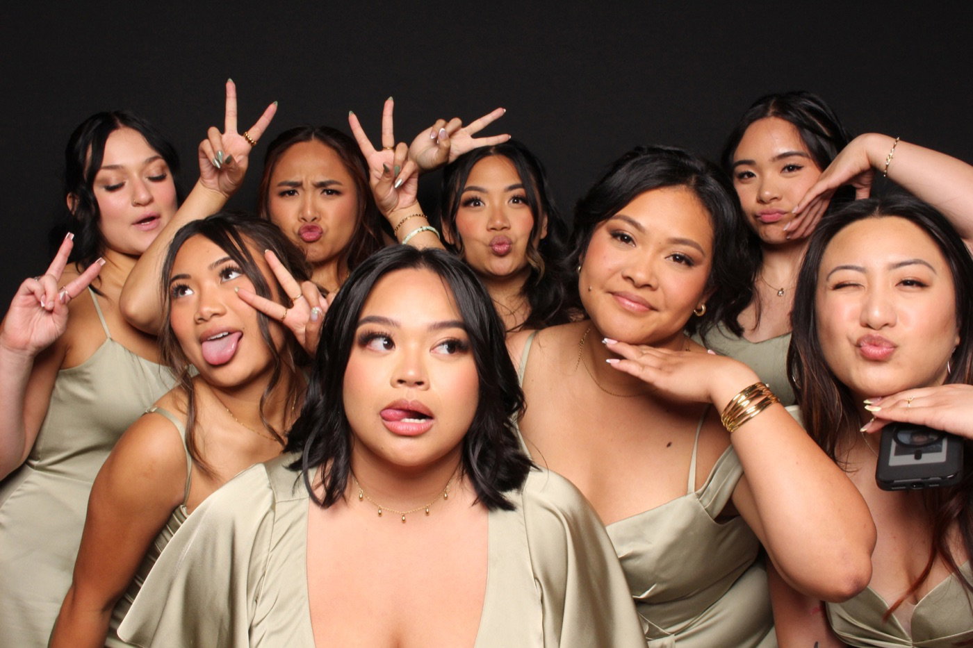Bridesmaids posing together against a black Glam Booth backdrop
